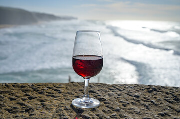 Tasting of tawny porto wine and   view on sandy beach and blue Atlantic ocean near Sintra in Lisbon area, Portugal