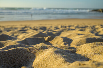 White sand glistening in sunlight during sunset on oceanic beach Magoito, Lisbon area, Portugal