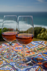 Tasting of sweet moscatel de setubal or porto portuguese wine and view on blue Atlantic ocean near Sintra in Lisbon area, Portugal