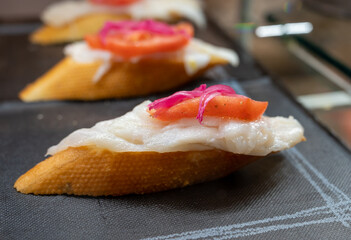 Typical snack of Basque Country, pinchos or pinxtos, small piece of bread with different fish and sea food toppings, served in bar in San-Sebastian or Bilbao, Spain