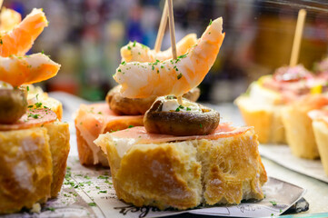 White board with typical snack of Basque Country, pinchos or pinxtos skewers with small pieces of...