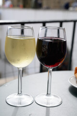 Drinking of red and white Portuguese wine in outdoor cafe at view point on old part of Lisbon city, Portugal
