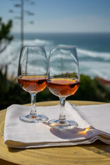 Tasting of sweet moscatel de setubal or porto portuguese wine and view on blue Atlantic ocean near Sintra in Lisbon area, Portugal