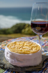 Tasting of tawny porto wine and local portuguese matured cheese queijo serpa with view on blue Atlantic ocean near Sintra in Lisbon area, Portugal