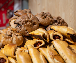 Spanish snacks and street food, baked pie empanadilla with different filling on market in San-Sebastian, Spain