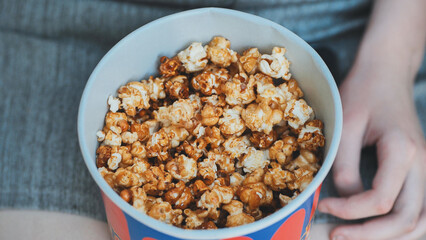 Friends eating popcorn on the street. Close-up of hands.