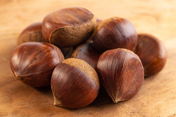 A Pile of Raw and Whole Chestnuts on a Wooden Table