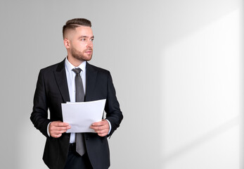 Dreaming handsome businessman wearing formal suit standing holdi