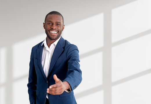 African businessman offer a hand to shake, empty white background