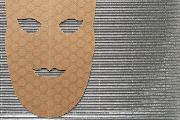 brown paper theatrical mask on corrugated texture - obrazy, fototapety, plakaty