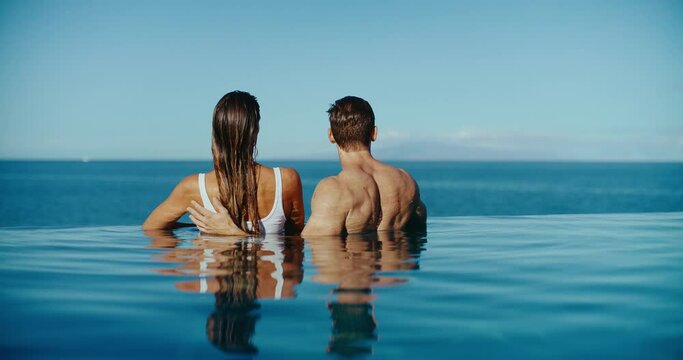 Attractive couple relaxing in the pool at tropical luxury resort spa, vacation honeymoon travel