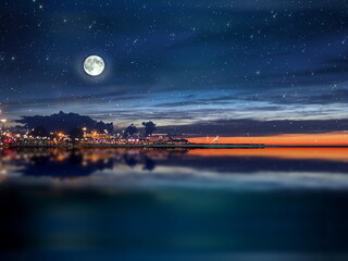  night sea water blurred city light,blue water wave  reflection  starry sky and moon in Italy  port...