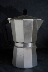Old italian coffee maker on black background