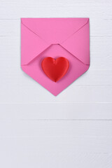 Valentines Day Concept: Two red hearts with a pink envelope on white wood table with copy space.