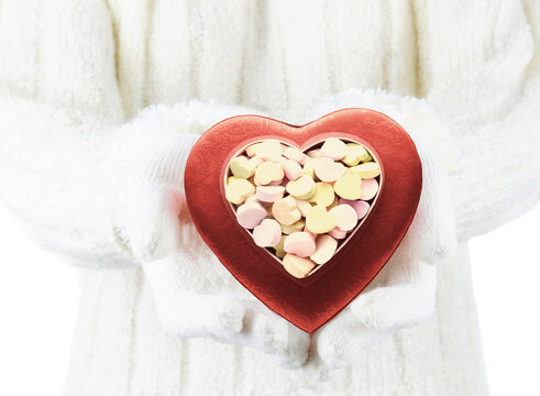 Valentines Day Concept, Woman Wearing A White Sweater And White Gloves Holding A Box Of Candy Hearts,  Shallow Depth Of Field