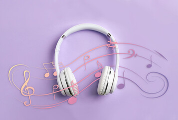 Staff with music notes and treble clef flowing over white headphones on lavender background, top...