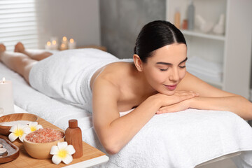 Obraz na płótnie Canvas Beautiful woman relaxing on massage table in spa salon