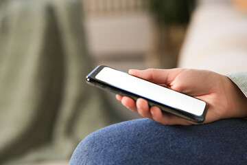 Closeup view of woman with smartphone indoors. Space for text