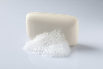 Soap with fluffy foam on white background