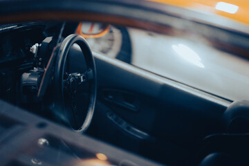 Obraz na płótnie Canvas Modern black car interior, steering wheel, gearshift lever and dashboard in vintage tones