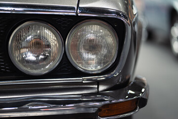 Fototapeta premium Close-up of the headlights of a vintage car, retro vintage car under the lights