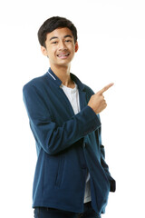 Young Asian teenage boy standing posing on a white background pointing his hand to empty space. - 557633021