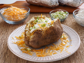 Stuffed Potato with Toppings and Potatoes In Background