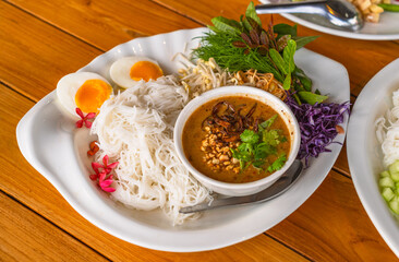 Thai vermicelli or rice noodles with peanut sauce curry, side dish with organic vegetables and boiled egg. Thai vermicelli or Thai rice noodle with curry is called Ka Nom Jean in the Thai language.