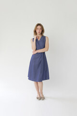 Serie of studio photos of young female model in cotton denim wrap sleeveless dress.