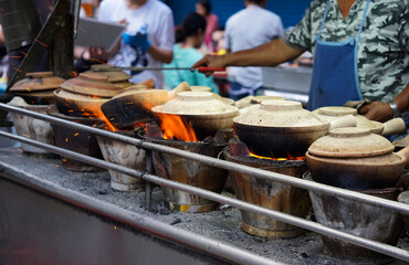 Man cooking chicken rice in clay pot in Chinatown street of Kuala Lumpur, Malaysia                 ...