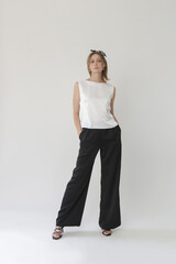 Serie of studio photos of young female model in black and white silk outfit, sleeveless blouse and...