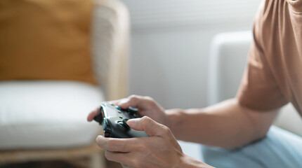 Young Asian man gamer controller video console playing holding hobby playful Online Video Game enjoyment eSport Cyber Games Internet. © Charlie's