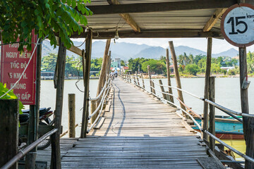 A veranda over the entrance to a rustic wooden bridge over a river at Nha Trang in Vietnam