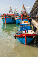Bright blue fishing boats tied to a pier at Vihn Luong Fishing Village in Vietnam