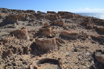 Barren coastal landscape with ancient limestone pipes resembling petrified wood