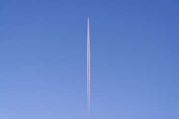  Flying airplane on blue sky background. Airplane flying in the blue sky sunlight. Trace from the plane