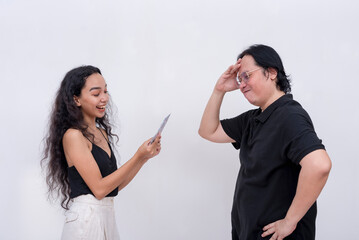 A young woman counts her money received from her reluctant and stressed out dad. Isolated on a white background.