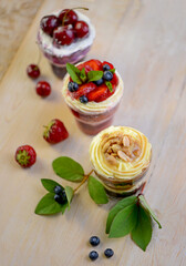 Homemade desserts in glass jars. Traditional unbaked Italian dessert on a white background. Cake with coffee, berries, fruits and mascarpone cream.