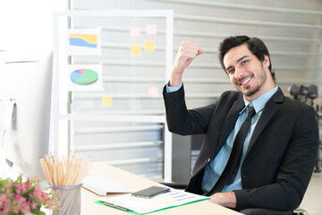 Portrait of businessman pushing his hand up to cheer up, business success concept