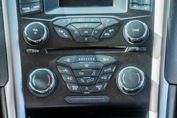 Radio tape recorder in the car with many toggle switches and buttons close-up	
