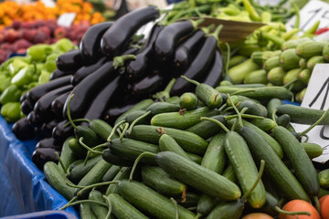 Green cucumbers and violet eggplants on market