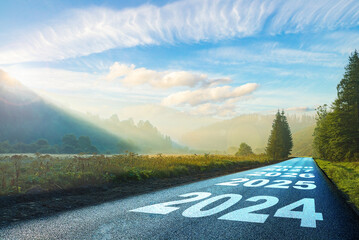 road on which is written 2024 at sunrise in the mountains ilis.beginning 2024. morning fog near the...