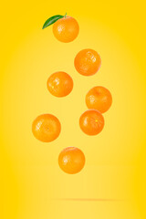 Isolated clementine on the air on yellow