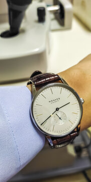 BANGKOK, THAILAND - DECEMBER 18 : Nomos Orion model, classic clean dial dress watch design in Glashutte, Germany with brown alligator leather strap wear on wrist in Bangkok, on December 18,  2022.