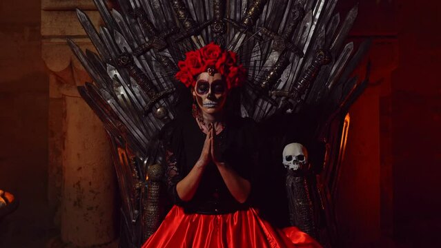 Carnival Day of the Dead The goddess of death in total darkness sits on a throne of iron swords on the sides fire burns and picks up a sugar skull.