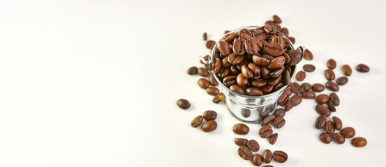 A metal bucket with a pile of scattered roasted coffee beans.