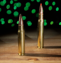 Large and smaller rifle ammo with Christmas lights behind