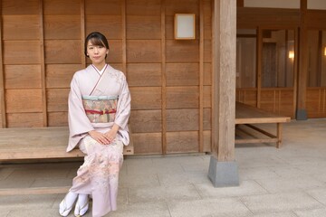 日本家屋にてポーズをとる若く美しい着物姿の女性	