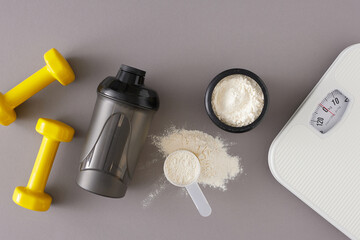 Gym diet nutrition concept. Flat lay photo of protein powder in jar with shaker, scoop, dumbbells...