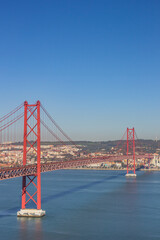 Historic red suspension bridge over the Tejo river in Lisbon, Portugal